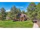Beautiful exterior elevation with expansive lawn surrounded by tall trees, creating a serene setting at 1332 Meadow Trl, Franktown, CO 80116