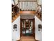 Grand foyer with hardwood floors, split staircase and french doors leading to the living room with a brick fireplace at 1332 Meadow Trl, Franktown, CO 80116