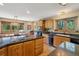 Well-lit kitchen featuring a large island with a cooktop, wooden cabinets, and a breakfast nook with large windows at 1332 Meadow Trl, Franktown, CO 80116