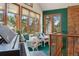 Cozy sun room with a piano, comfortable seating, and a beautiful view of the outdoors at 1332 Meadow Trl, Franktown, CO 80116