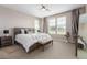 Bright bedroom with three windows, neutral colors, ceiling fan, and stylish decor at 8953 Southurst St, Littleton, CO 80129