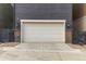Attached garage with decorative brick accents and adjacent small, fenced yard area at 8953 Southurst St, Littleton, CO 80129