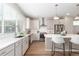 Modern kitchen featuring white cabinets, stainless steel appliances, and a spacious center island with bar stools at 8953 Southurst St, Littleton, CO 80129