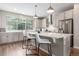 Bright, modern kitchen with stainless steel appliances, white cabinets, and a large center island with bar seating at 8953 Southurst St, Littleton, CO 80129