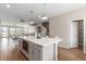 Open concept kitchen with an island, stainless steel microwave, and view to the living and dining areas at 8953 Southurst St, Littleton, CO 80129