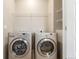 Well-lit laundry room with side-by-side washer and dryer, and shelving at 8953 Southurst St, Littleton, CO 80129