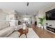 Open-concept living space featuring hardwood floors, modern decor, and seamless flow between living room and kitchen at 8953 Southurst St, Littleton, CO 80129