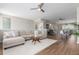 Spacious living room with hardwood floors, neutral paint and stylish decor opens to adjacent kitchen and dining area at 8953 Southurst St, Littleton, CO 80129