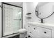 Modern bathroom featuring a glass shower, black shelving, and a sleek vanity mirror at 3470 S Poplar St # 401, Denver, CO 80224