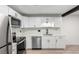 Bright kitchen featuring stainless steel appliances, white cabinets, and eye-catching herringbone tile backsplash at 3470 S Poplar St # 401, Denver, CO 80224