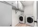 Well-equipped laundry room featuring a washer, dryer, and overhead storage cabinets at 3470 S Poplar St # 401, Denver, CO 80224
