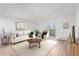 Staged living room featuring a comfortable couch, sleek coffee table, and well-lit with natural light at 3470 S Poplar St # 401, Denver, CO 80224