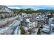 An aerial view shows a beautiful, snow-covered roofed home in a picturesque mountain community setting at 62 Broken Lance Dr # 202E, Breckenridge, CO 80424