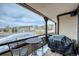 A covered patio with comfortable seating and a grill overlooks snow-covered landscape in this attractive home at 62 Broken Lance Dr # 202E, Breckenridge, CO 80424