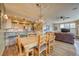 Open dining area with rustic chandelier, seamlessly connected to the kitchen and living spaces, bathed in natural light at 62 Broken Lance Dr # 202E, Breckenridge, CO 80424