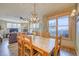 Inviting dining room featuring a rustic chandelier, large windows, and comfortable seating at 62 Broken Lance Dr # 202E, Breckenridge, CO 80424