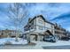 Attractive three-story home with stucco exterior, a stone foundation, an attached garage, and well-manicured landscaping at 62 Broken Lance Dr # 202E, Breckenridge, CO 80424
