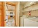 The laundry area is conveniently located near the kitchen and is equipped with a washer, dryer, and overhead shelving at 62 Broken Lance Dr # 202E, Breckenridge, CO 80424