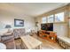 Bright living room with comfortable seating, TV, and stone fireplace, enhanced by natural light at 62 Broken Lance Dr # 202E, Breckenridge, CO 80424