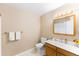 Well-lit bathroom with wooden vanity, modern fixtures, and clean white towels at 1459 S Pierce St, Lakewood, CO 80232