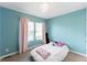 Bright bedroom features blue walls, a window, a bed, and carpeted floors at 1459 S Pierce St, Lakewood, CO 80232