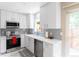 Modern kitchen featuring white cabinets, stainless steel appliances, and marble flooring at 1459 S Pierce St, Lakewood, CO 80232
