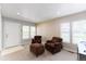 Comfortable living room featuring chairs, windows, carpet flooring, and a front entry door at 1459 S Pierce St, Lakewood, CO 80232