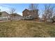 Spacious backyard with a well-maintained lawn, a deck with patio furniture, and mature trees at 5404 Fawn Ridge Way, Castle Rock, CO 80104
