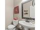 Cozy powder room with a pedestal sink, decorative mirror, and neutral color scheme at 5404 Fawn Ridge Way, Castle Rock, CO 80104