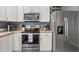 Updated kitchen features stainless steel appliances, a tile backsplash, and white cabinetry at 5404 Fawn Ridge Way, Castle Rock, CO 80104