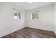Cozy bedroom featuring modern wood floors, neutral walls, and two bright windows at 4401 W Mississippi Ave, Denver, CO 80219
