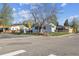 Charming single-story home featuring a fenced yard on a corner lot with mature trees at 4401 W Mississippi Ave, Denver, CO 80219
