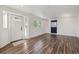 Spacious living area featuring modern wood floors, white walls, and a welcoming front door at 4401 W Mississippi Ave, Denver, CO 80219