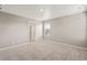 Neutral-toned bedroom with carpet, a window, and a view into the en-suite bathroom at 864 Leeward St, Lochbuie, CO 80603
