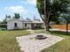 Large backyard has a brick firepit and a mature tree for shade at 1670 Oakland St, Aurora, CO 80010