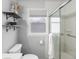 Bright bathroom featuring glass shower doors, a white tile shower, and open shelves for decor, a tranquil retreat at 1670 Oakland St, Aurora, CO 80010