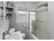 Bright bathroom with shelves, a frosted glass shower door, and a white tile shower that provides a clean and inviting space at 1670 Oakland St, Aurora, CO 80010