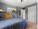 Inviting bedroom showcasing a queen bed, wood floors, modern lighting, decor, and an open doorway to the bathroom at 1670 Oakland St, Aurora, CO 80010