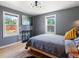 Bedroom boasts hardwood floors, two windows, and a modern light fixture with an abstract painting adding a touch of artistry at 1670 Oakland St, Aurora, CO 80010