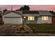 Charming ranch-style home featuring solar panels, attached garage, and well-lit entry, set against a beautiful sunset sky at 1670 Oakland St, Aurora, CO 80010
