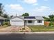Inviting single-story home featuring solar panels, an attached garage, and a quaint front yard at 1670 Oakland St, Aurora, CO 80010