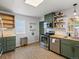 Charming kitchen features stainless steel appliances, green cabinetry, and wood flooring at 1670 Oakland St, Aurora, CO 80010