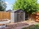 Backyard storage shed next to garden boxes with rock landscaping and wood fence at 1670 Oakland St, Aurora, CO 80010