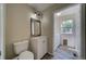 Well lit, neutral toned bathroom with modern fixtures, wood look flooring and open access to the laundry room at 12535 S Beaver Creek Way, Parker, CO 80134