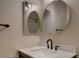 Elegant bathroom featuring a modern sink with oil rubbed bronze faucet, quartz countertop, and oval mirrors at 12535 S Beaver Creek Way, Parker, CO 80134