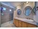 Bright bathroom with double sinks, oval mirrors, and tiled shower at 12535 S Beaver Creek Way, Parker, CO 80134