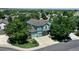 Aerial view of a blue home with a three-car garage surrounded by mature trees at 12535 S Beaver Creek Way, Parker, CO 80134