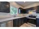 Updated kitchen with stainless steel appliances, dark cabinets, and a bright window at 12535 S Beaver Creek Way, Parker, CO 80134