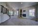 Spacious living room boasting a fireplace with brick surround and staircase with dark metal railings at 12535 S Beaver Creek Way, Parker, CO 80134