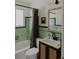 Stylish bathroom featuring green tiles, a classic shower with a vintage-inspired vanity, and a woven door cabinet at 4422 W 27Th Ave, Denver, CO 80212